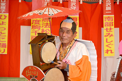 チンドン太鼓と背負いビラを担ぐ、相沢寿男さん。