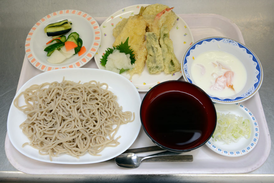 手打ち蕎麦、天ぷら、漬物、そしてデザートのヨーグルト。蕎麦打ち職人＆『えがお』調理スタッフのコラボレーション定食です。
